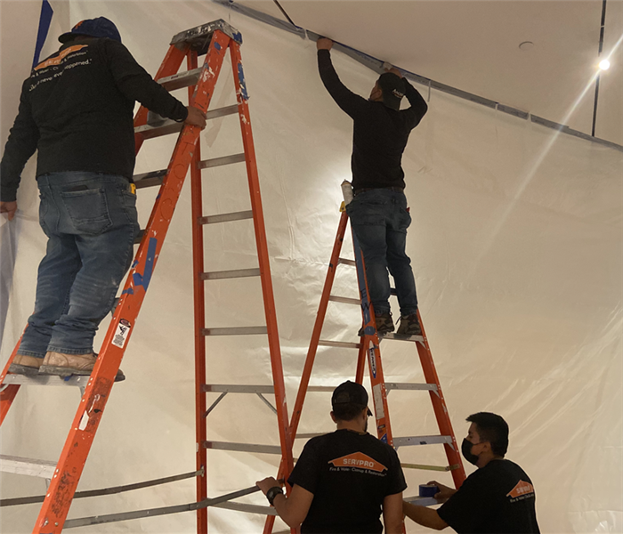 Using ladders to reach the high ceilings